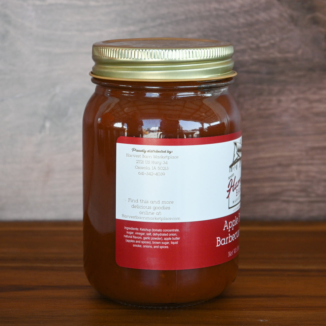 Jar of apple butter with a red label on a wooden surface