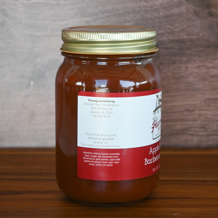 Jar of apple butter with a red label on a wooden surface