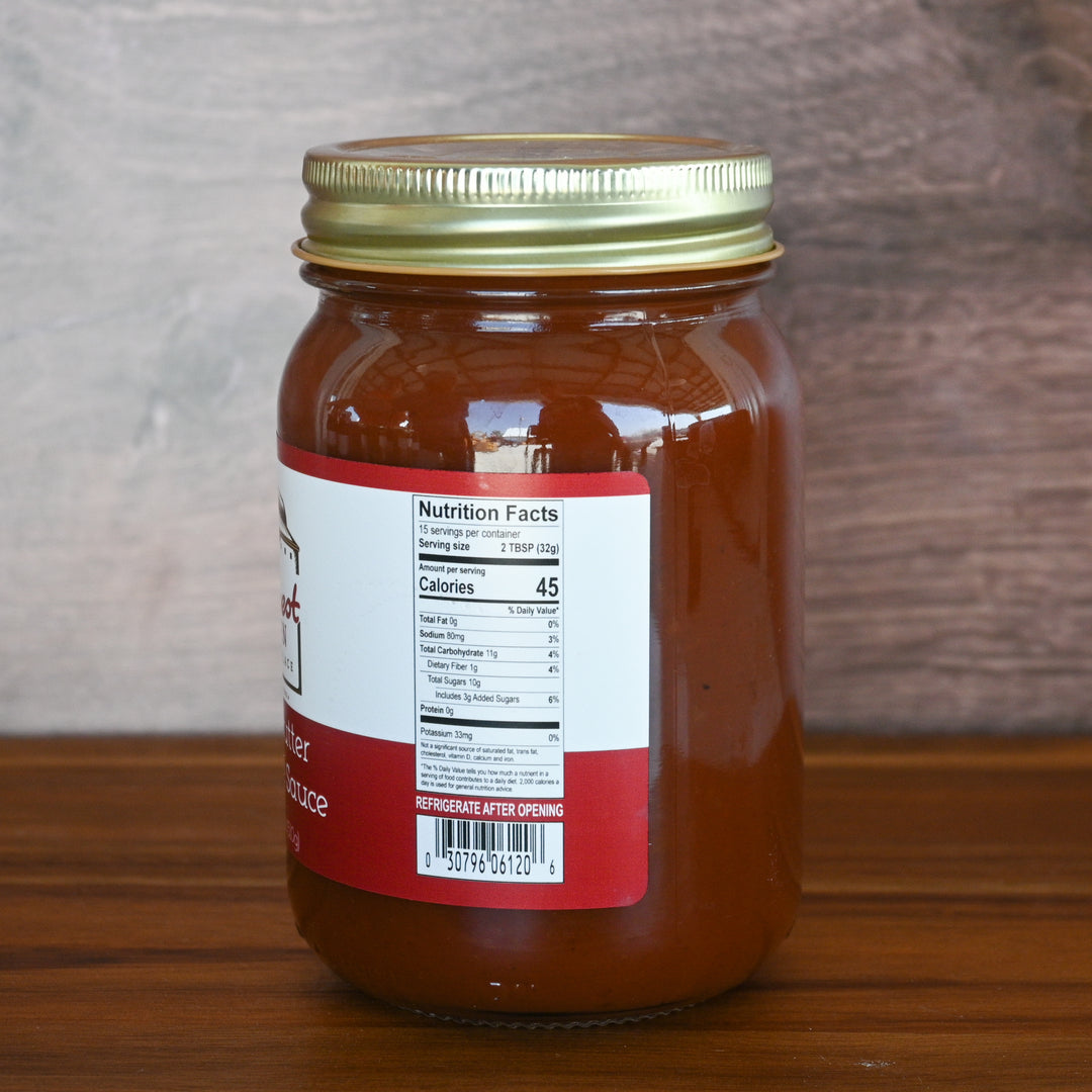 Jar of sauce with a nutrition label on a wooden surface