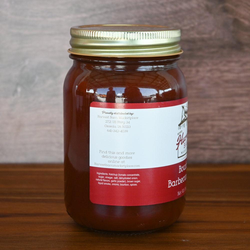 Jar of barbecue sauce with a red label on a wooden surface