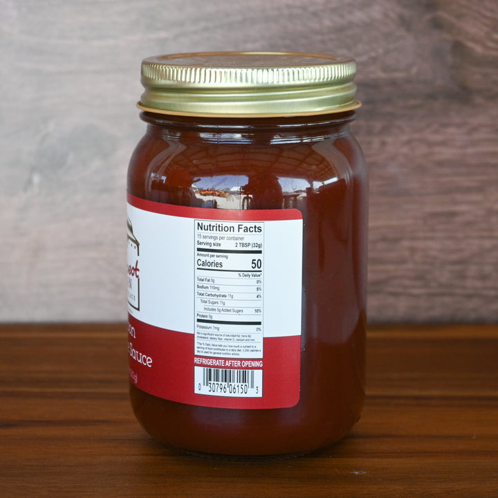 Jar of sauce with a red label on a wooden surface