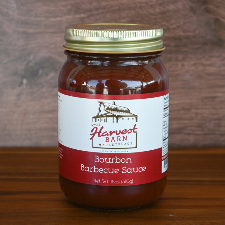 Jar of Bourbon Barbecue Sauce from Harvest Barn Marketplace on a wooden surface with a wooden background