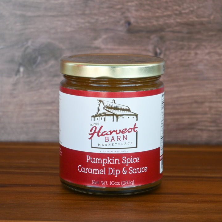 Jar of Harvest Barn Pumpkin Spice Caramel Dip & Sauce on a wooden surface with a wooden background